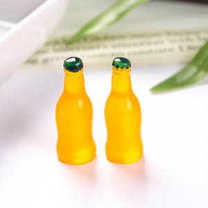 Close-up of translucent orange resin soda bottles with green caps and bubble details