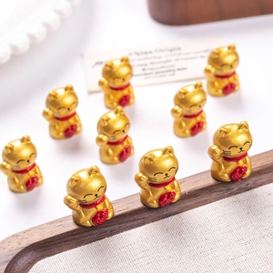 Detailed view of miniature gold resin lucky cat figurines on a wooden tray with fabric liner
