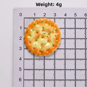 Makro-Detail eines 3 cm runden Harz-Gemüseplätzchen-Anhängers mit realistischen Kräutern