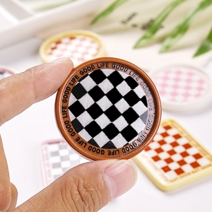 Macro detail of miniature resin checkered plate with Good Life engraved border for DIY crafts