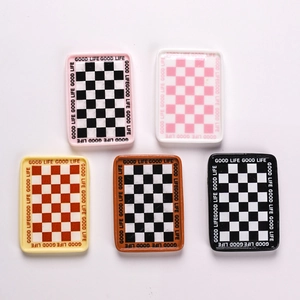 Detailed macro view of five miniature resin checkered plates with Good Life text borders