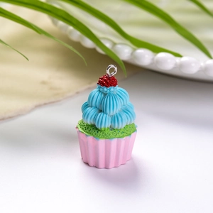 Λεπτομερής λήψη από πολύχρωμο μενταγιόν cupcake με παστέλ στρώσεις κρέμας για τσάντες