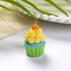 Μακροφωτογραφία πολύχρωμου μενταγιόν cupcake με πράσινη βάση και κίτρινη διακόσμηση