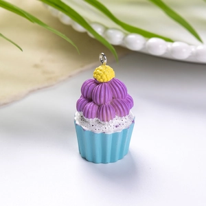 Λεπτομέρεια από το μωβ και μπλε μενταγιόν cupcake από ρητίνη με μεταλλικό δακτύλιο