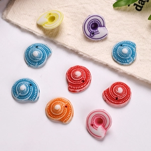Detailed close-up of colorful snail-shaped beads with spiral textures for DIY jewelry