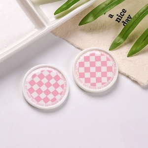 Detailed macro view of miniature resin plates featuring a pink and white checkerboard pattern