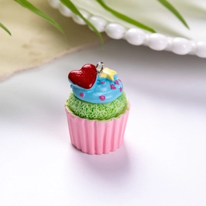 Λεπτομερής λήψη με πολύχρωμο μενταγιόν cupcake από ρητίνη με ροζ βάση και μπλε κρέμα σε λευκό