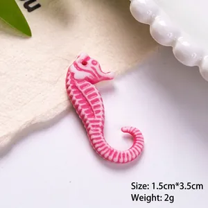 Macro detail of pink and white striped resin seahorse charm for DIY jewelry
