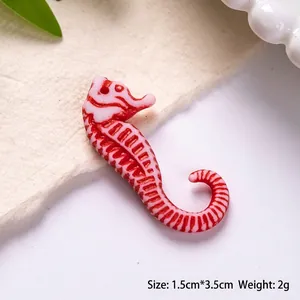 Macro view of a 3.5cm red and white striped acrylic seahorse bead for DIY jewelry making