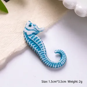 Detail of blue and white seahorse acrylic bead with dimensions 1.5cm by 3.5cm for DIY crafts