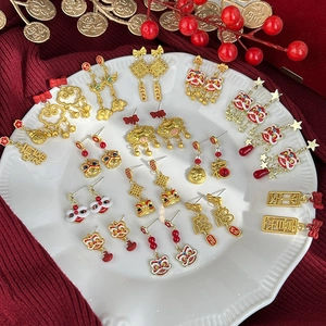 Detalle de pendientes rojos y dorados de Año Nuevo Chino con motivos de león y nubes de suerte