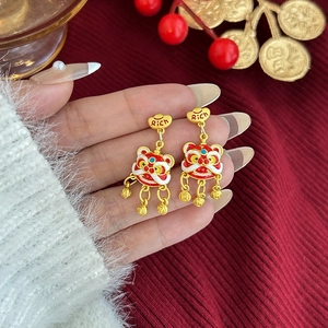 Detalle de pendientes de león esmaltados en rojo con gancho de lingote dorado y Rich