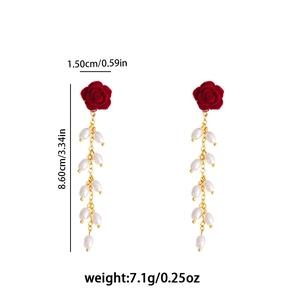 Detail view of red velvet rose earrings with gold tassels and white pearls, 8.6cm length