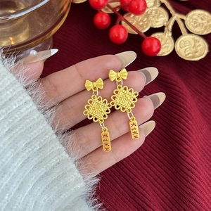 Detalle de pendientes rojos y dorados de Año Nuevo Chino con colgantes de la fortuna
