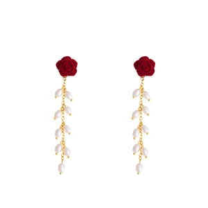 Detail of velvet red rose earrings with golden chains and dangling white drop pearls