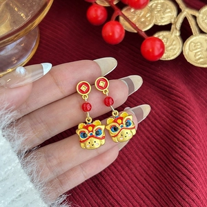 Detalle macro de pendientes de león chino con esmalte y monedas doradas de la suerte