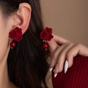 Detail of model wearing velvet rose earrings with dark red pearl drops in vintage style