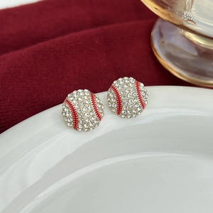 Macro shot of baseball stud earrings with white rhinestones and red enamel stitching details