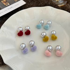 Set of five colorful velvet heart and pearl drop earrings displayed on a white plate