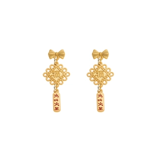 Detalle de pendientes rojos festivos con nudos de la suerte y símbolos de fortuna