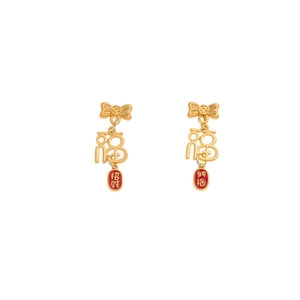 Detalle de pendientes rojos y dorados del Año Nuevo Chino con amuletos de la suerte