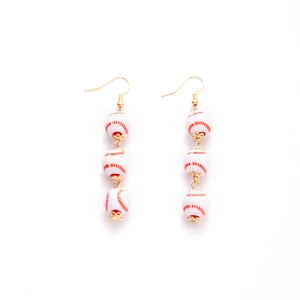 Detailed view of long earrings with red baseball stitching patterns on white beads