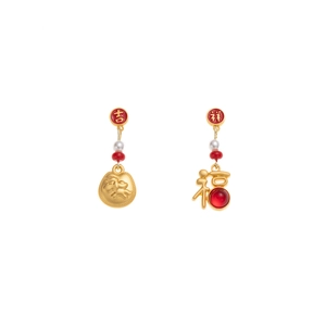 Detalle de pendientes asimétricos de Año Nuevo con bolsas de la suerte rojas y perlas