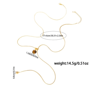 Dettaglio collana lunga dorata da 83cm con sfera marrone scuro e piccolo ciondolo tondo