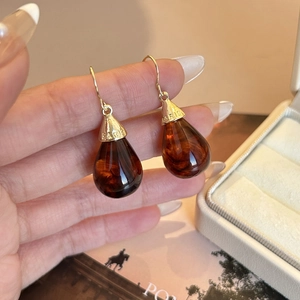 Pendientes vintage de ámbar en forma de gota con tapa dorada grabada Paris en la mano