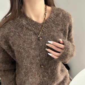 Collana lunga bohémien in occhio di tigre con nappa dorata indossata da modella
