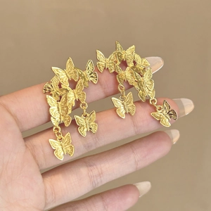 Eleganti orecchini a farfalla dorati con trama in metallo spazzolato per un look chic