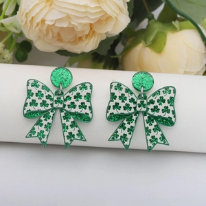 Saint Patrick's Day acrylic bow earrings featuring green glitter shamrock patterns