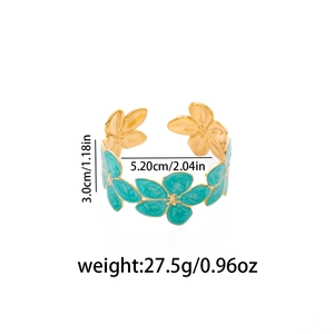 Dettaglio del bracciale a polsino dorato irregolare con fiori in smalto blu e misure