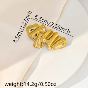 Detail of gold wrinkled wavy brooch showing 6.5cm length and high-polished metallic texture