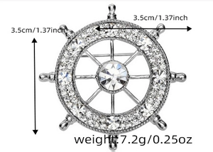 Detail view of silver nautical helm brooch with sparkling crystals and size measurements