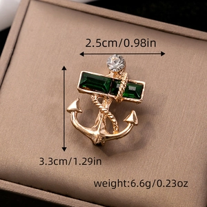 Macro shot of a nautical anchor brooch with green emerald gems and dimension measurements