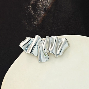 Polished silver metal angel brooch featuring a minimalist abstract wrinkled design