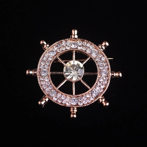 Detailed close-up of a rose gold helm brooch with sparkling clear crystal rhinestones