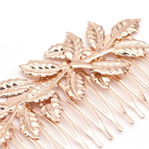 Detail of champagne gold leaf hair comb featuring intricate embossed leaf veins texture