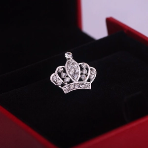 Dettaglio di una spilla a corona in argento con cristalli in una confezione regalo