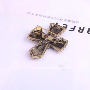 Detail view of the vintage pearl cross brooch showing the metal back and secure pin clasp