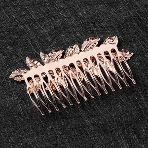 Detailed view of rose gold leaf hair comb with intricate leaf vein textures on black fabric