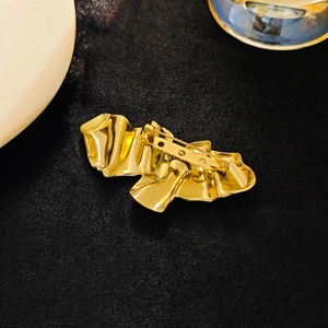 Abstract golden pleated angel wing brooch with a safe metal pin on black satin