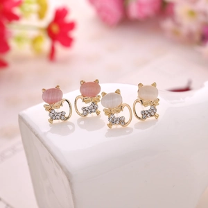 Exquisite cat shaped stud earrings with opal stones and crystals on white ceramic stand