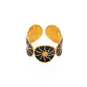 Dettaglio di bracciale rigido dorato vintage con monete smaltate nere e raggi solari