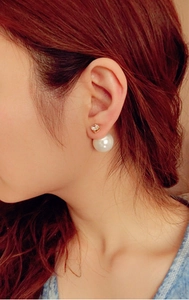 Close-up of double-sided earrings featuring a square zircon stud and large white pearl