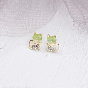 Detailed close-up of gold-plated cat stud earrings with green opal and white crystals