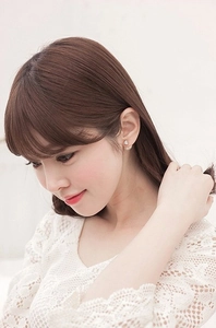 Close-up of double-sided stud earrings with zircon crystal and creamy white pearl detail