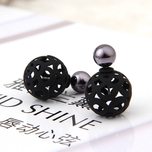 Detailed macro view of double-sided hollow ball stud earrings with black matte finish