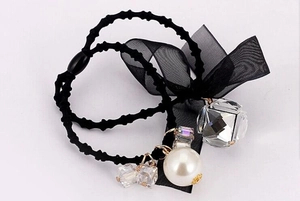 Detail view of black mesh bow hair tie with faux pearl and faceted crystal bead charms